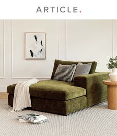 a living room with a green couch and white walls