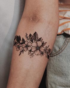 a black and white flower tattoo on the arm