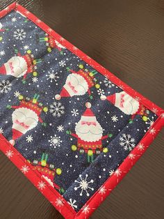 a close up of a christmas themed placemat on a wooden table with snowflakes