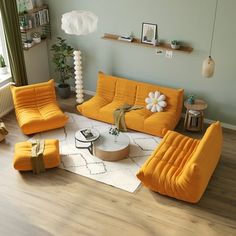 a living room with yellow couches and white rugs on the wooden flooring