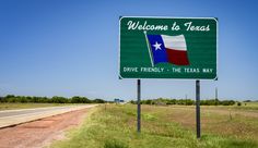 a welcome to texas sign on the side of the road in front of a highway