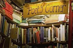 there is a sign that says poeb's corner in front of a bookshelf full of books