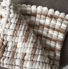 a close up of a blanket on a couch with the fabric pulled back to show it's texture