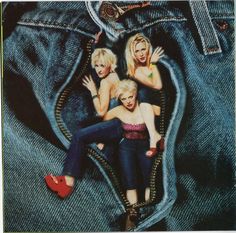 three women sitting on the back of a pair of jeans