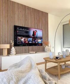 a living room filled with furniture and a large flat screen tv mounted on the wall