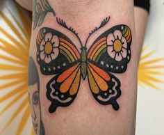 a colorful butterfly tattoo on the leg