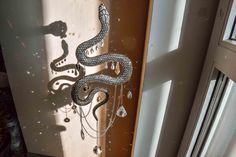 a snake sculpture hanging from the side of a window sill next to a door