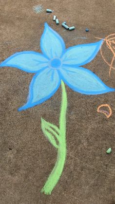 a blue flower drawn on the ground with crayons