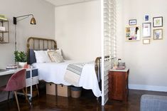 a bed room with a neatly made bed next to a desk