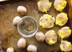 potatoes and eggs on a baking sheet with a small glass jar in the middle next to them