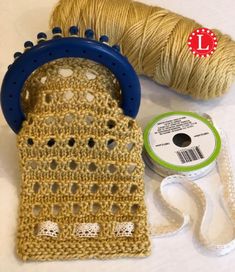 a crochet bag next to a spool of thread and a spool of yarn