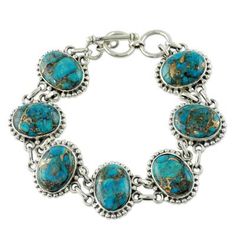 Revealing golden veins blue-green gemstones lend their mystical color to this handcrafted bracelet. Shanker designs the piece and showcases composite turquoise in ornate sterling silver settings. .925 Sterling silver Spiritual Oval Sterling Silver Bracelet, Bohemian Sterling Silver Oval Bracelets, Bohemian Oval Sterling Silver Bracelets, Elegant Turquoise Oval Sterling Silver Bracelet, Artisan Cabochon Bracelet Jewelry, Southwestern Silver Bracelets With Natural Stones, Bohemian Sterling Silver Turquoise Bracelet, Bohemian Oval Silver Bracelet, Bohemian Oval Sterling Silver Bracelet