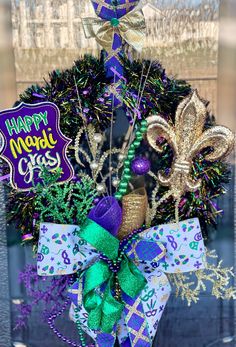 a mardi gras wreath with purple, green and gold decorations