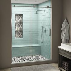 a bathroom with a walk in shower next to a white sink and a gray rug