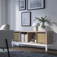 a living room with white furniture and pictures on the wall