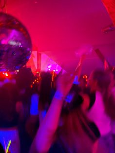 people dancing at a party with disco balls in the background