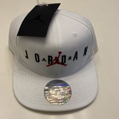 Get Your Head In The Game With The Jordan Jumpman Air Snapback. Embedded With A Cotton Twill Sweat Band, You Can Get Active Without Getting Sweat In Your Eyes. Not To Mention The Flat Brim Is Embroidered With A Woven Jordan Label For A Nice Finishing Touch. Heavy Poly Twill With Cotton Twill Sweat Band. Flat Brim Snapback Hat With Embroidery And Woven Label. White Snapback Visor Hat With Letter Print, White Letter Print Snapback Visor Hat, White Letter Print Visor Snapback Hat, White Snapback Hat For Sports With Flat Brim, White Hip Hop Snapback Hat With Letter Print, White Breathable Flat Bill Baseball Cap, White Hip Hop Hat For Streetwear, White Snapback Sports Hat, White Cotton Snapback Hat For Sports Events