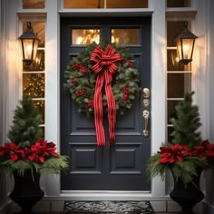 a front door decorated with christmas wreaths and poinsettis for the holiday season