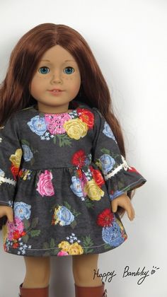 a doll with long brown hair wearing a floral dress