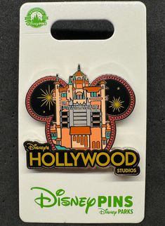 the hollywood studios logo is on top of a disney pinback that has been placed in front of a white package