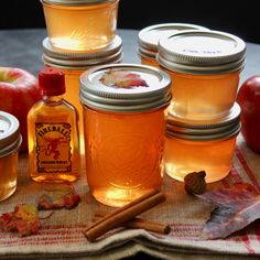 several jars filled with apple cider sitting on top of a table