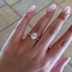 a woman's hand with a diamond ring on it