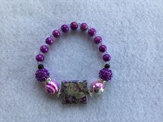 This is a beautiful stretch bracelet comprised of different shades of purple beads, different shapes, & patterns. This should sit most women, teenagers, & probably preteen-ish aged/size girls. A must have for purple lovers! *Could be a possible choking hazard, keep away from children under 5. Trendy Handmade Purple Stretch Bracelet, Purple Stretch Bracelet With Round Beads As Gift, Adjustable Casual Purple Beaded Bracelets, Casual Purple Stretch Bracelet As A Gift, Casual Purple Stretch Bracelet For Gift, Casual Purple Stretch Bracelet As Gift, Casual Purple Stretch Bracelet Gift, Adjustable Purple Beaded Bracelets Casual Style, Casual Purple Beaded Bracelets