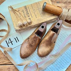 two wooden shoes sitting on top of a piece of paper next to a pair of scissors