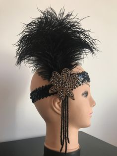 This is a very nice headpiece inspired on Great Gatsby movie and this is perfect for your vintage themed wedding or Gatsby party! This piece is unique and I will not produce more. Free shipping to US and Spain:) It is decorated with lots of sparkling dark and golden beads on a stretch sequins headband to fit all sizes. It is really comfortable to wear despite the size of the stunning black feathers attached that are 23 cm long (9 inches). Buy the Great Gatsby bracelets, earrings and other pieces Gold Art Deco Flapper Dress For Party, Vintage Adjustable Headband For Parties, Elegant Black Flapper Dress For Costume, Vintage Adjustable Headpiece For Carnival, Adjustable Gatsby Style Headpiece For Carnival, Gold Gatsby Headpiece For Vintage Events, Adjustable Flapper Headband For Evening, Vintage Adjustable Costume Accessories For Carnival, Elegant Adjustable Headpieces For Costume Party