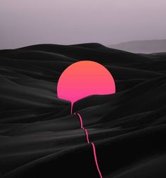 a pink balloon floating in the middle of a desert