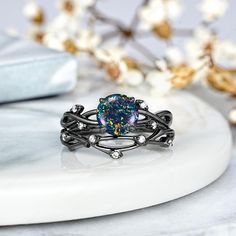 a ring with an opal stone in the center on top of a white surface