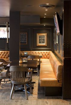 a restaurant with wooden tables and leather couches