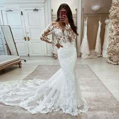 a woman is taking a selfie in her wedding dress while looking into the mirror