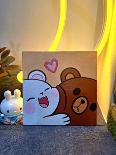 a painting of a bear hugging a teddy bear on a canvas next to some other items