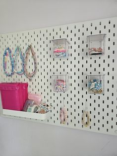 there is a white pegboard with several different items on it and some plastic bins