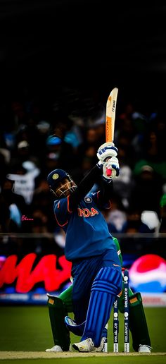 a man holding a cricket bat on top of a field