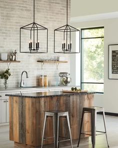 a kitchen with two stools next to an island in the middle of the room