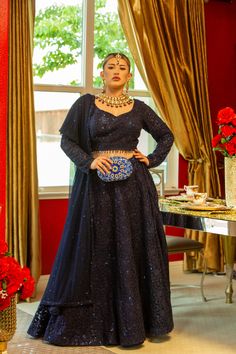 Adorned with intricate self-sequins, this deep blue masterpiece is sure to dazzle in the Adhara Lehenga. The look is completed with a full-sleeve blouse and a net dupatta that has been embellished with sparkling details. Pure luxury awaits in the Adhara Lehenga, an incredible work of art in a deep blue hue with intricate self-sequins that will leave you mesmerized. Team it up with an intricately designed full-sleeve blouse paired with a net dupatta embellished with sparkly details for the fashio Long Sleeve Choli With Sheer Dupatta For Navratri, Designer Long Sleeve Lehenga With Sheer Dupatta, Long Sleeve Traditional Wear With Sequins For Navratri, Reception Long Sleeve Blouse With Sheer Dupatta, Anarkali Blouse Piece With Dupatta For Evening, Festive Evening Lehenga With Long Sleeves, Blue Sequined Traditional Wear For Wedding, Blue Long Sleeve Choli With Dupatta, Elegant Blue Choli With Sequins