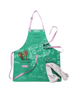 a green apron with utensils in it next to an oven mitt and spatula