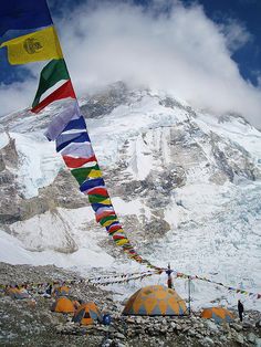 tents and flags in front of a snowy mountain