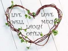 a heart - shaped plant with vines and words written on it that says, live love well mooch laugh often