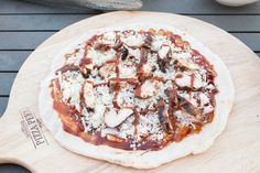 a pizza sitting on top of a wooden cutting board