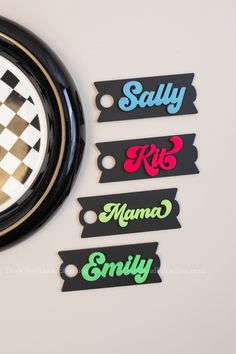 four name tags attached to a clock on a white wall with checkerboard design