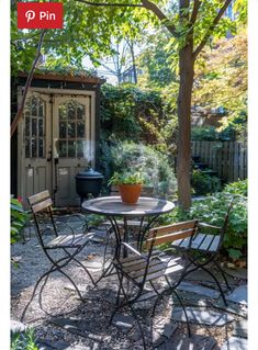 an outdoor table and chairs in a garden