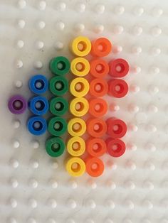 several different colored toothbrushes sitting on top of a white surface with holes in the middle