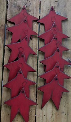 four red metal leaves hanging on a wooden fence