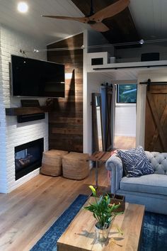 a living room filled with furniture and a flat screen tv mounted on the wall above a fireplace