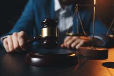 a man sitting at a table in front of a judge's hammer and scale