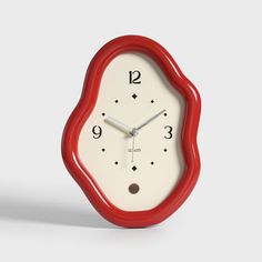 a red and white clock sitting on top of a table