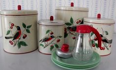 three canisters with birds painted on them sitting next to each other and one has a red lid